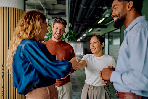 Fotografie Diverse business people shaking hands, smiling at a successful agreement during