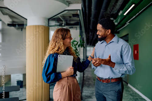 Fotografie Diverse business colleagues talking and smiling during a discussion in a modern