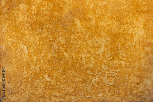 Foto Detalle frontal de muro pintado color ocre o mostaza vibrante, textura y desgaste natural