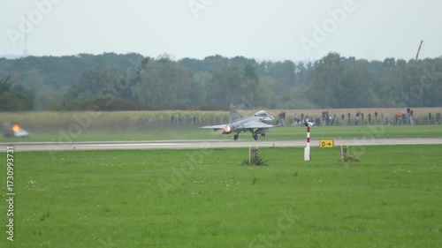 JAS-39C Gripen takes off, jet stream soaring in clear countryside