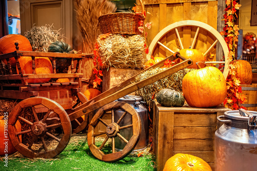 A beautiful composition on the theme of Halloween: pumpkins, rustic carts, bales of straw.