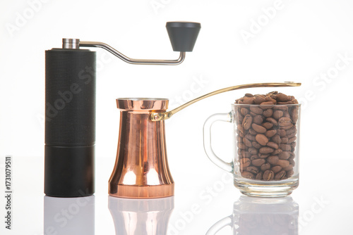 Coffee grinder and brewing pot with coffee beans on white background in a kitchen setting
