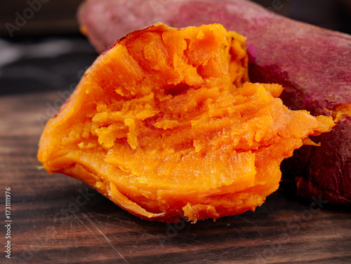 Fresh Red Sweet Potato Cut in Half Showing Orange Flesh Interior on Wooden Board