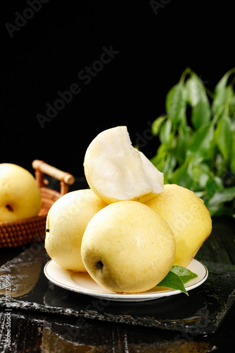 Fresh Sweet Crown Pears from Hebei China on Plate with Green Leaves and Rustic Kitchen Setting