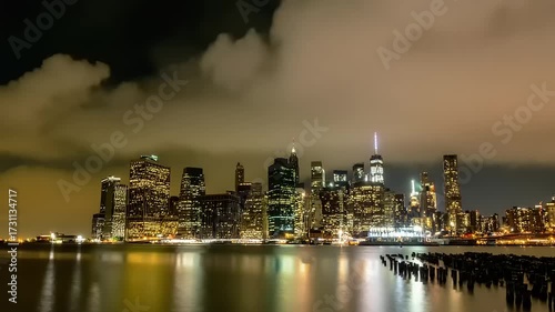 City skyline illuminated at night with cloudy sky and water reflection