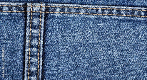 Close up of blue denim jeans fabric with visible stitching and texture
