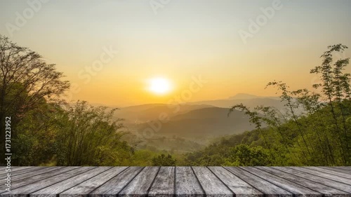Sunrise over misty mountains with bamboo and wooden deck
