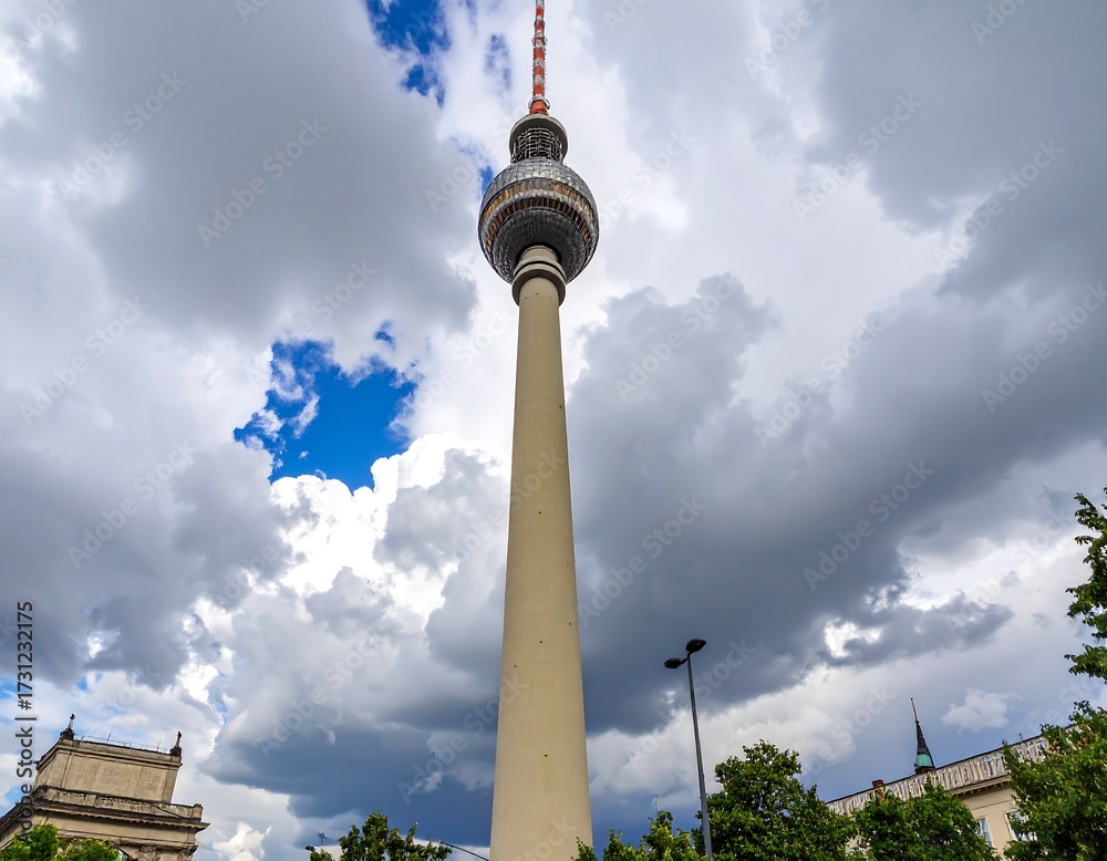 Naklejka premium Tall slender tower against a dramatic, cloudy sky