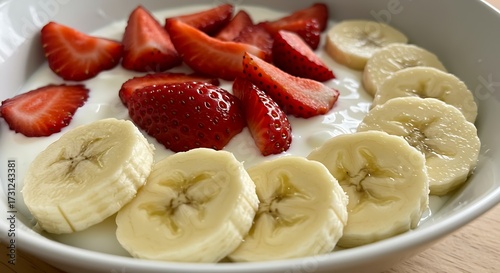 Fresh fruit breakfast bowl yogurt with sliced strawberries and bananas
