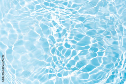 Blue water with ripples on the surface. Defocus blurred transparent blue colored clear calm water surface texture with splashes and bubbles. Water waves with shining pattern texture background.