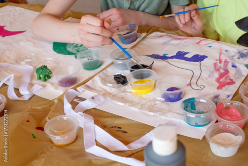 Fotografie Kids art class painting creatively on canvas totes for birthday party activity