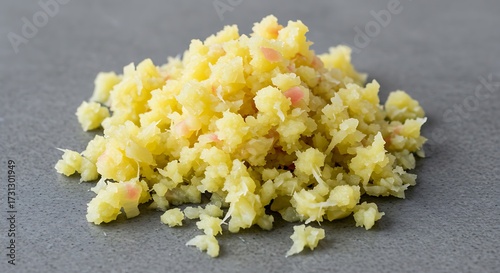 Heap of minced ginger on a gray surface culinary ingredient