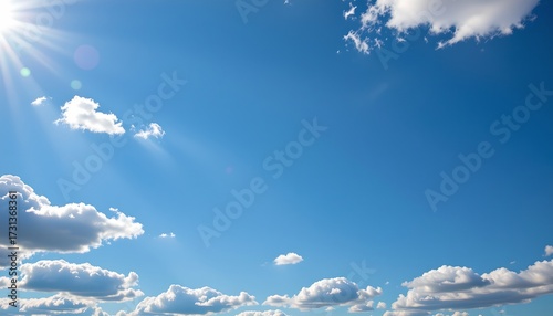 Fototapeta Naklejka Na Ścianę i Meble -  An expansive sky filled with fluffy clouds under a bright blue expanse, suggesting a clear, sunny day.