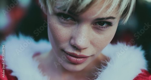 Festive Close-Up Portrait of a Santa-Clad Woman with Short Blonde Hair and Winter Night Bokeh.