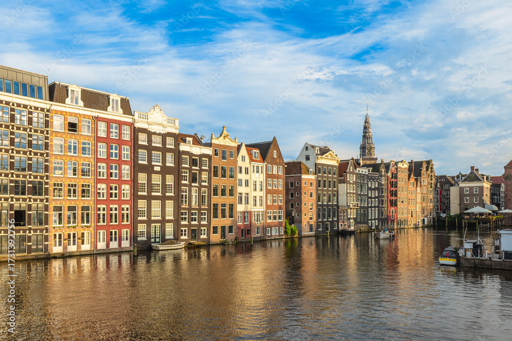 Fototapeta premium Scenery of Damrak in Amsterdam, Dutch. The houses located direct on the water