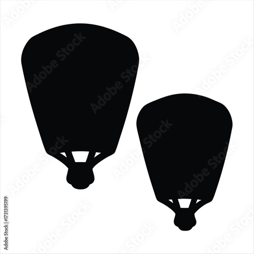 Two Chinese sky lanterns drifting upwards in a black and white silhouette