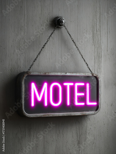 Retro motel neon sign glowing against a textured grey wall.