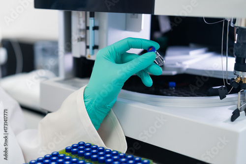 Obraz na plátně Close up woman scientist in rubber gloves puts the vial to HPLC system with auto sampler