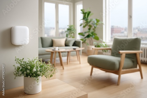 Modern White Smart Thermostat on Interior Wall with Plants and Furniture in Bright Daylight