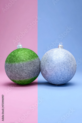 Beautifully crafted Christmas ornaments resting on a pink and blue background, showcasing modern holiday decor styles
