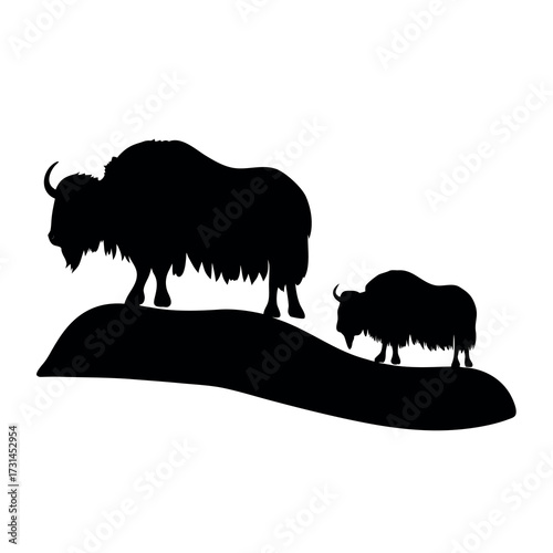 Silhouette of a large yak and a smaller yak standing on a rocky outcrop