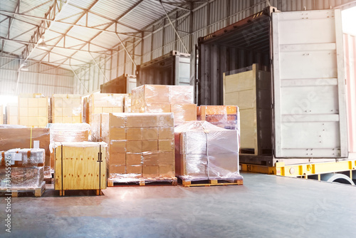 Bulk of Package Boxes Waiting to be Loaded into Containers Trucks. Forklift Pallet Jack. Distribution Warehouse, Shipping Cargo Container. Freight Truck Logistics Transportation.	
