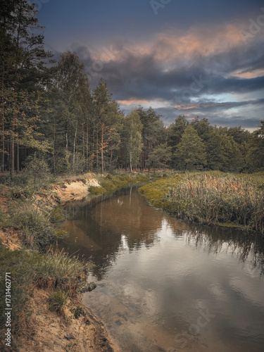 A small river and the surrounding landscape, exemplified by the Grabia River, Poland.