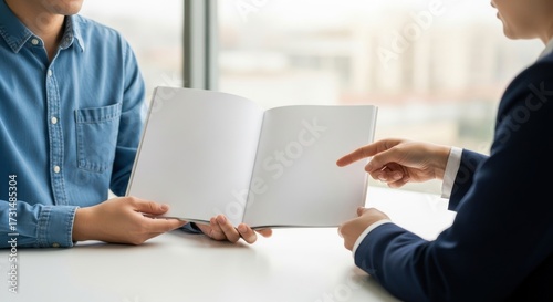 A man and a woman are sitting at a table with a book open in front of them