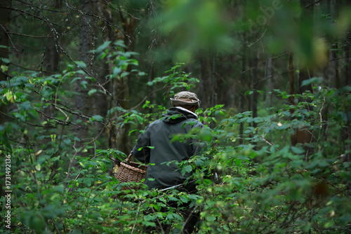 Man Foraging in Dense Forest with Woven Basket for Natural Harvesting Adventure