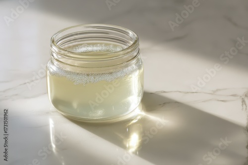 Glass Jar Filled with Clear Liquid and Sunlight Creating Soft Shadows