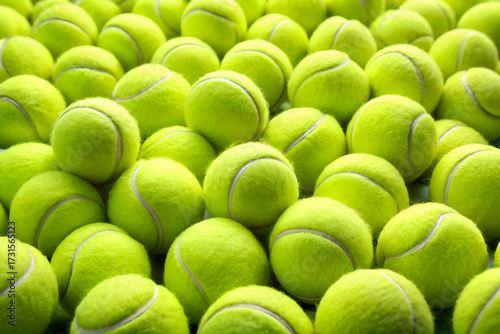 Close-up view of many yellow tennis balls. arranged in a pile.  Perfect for sports themes and backgrounds.