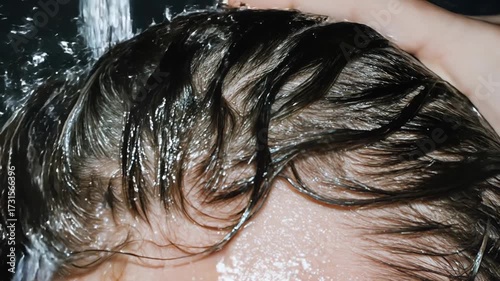Both hands scrubbing hair beneath a rush of water, rich foam floating past the temples; a tactile lifestyle scene designed for shampoo, spa and clean‑beauty brands that prize sensorial detail and self