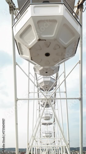 Big white Ferris wheel. Modern ferris wheel at carnival. Amusement Park Ride. Travel and Leisure Concept