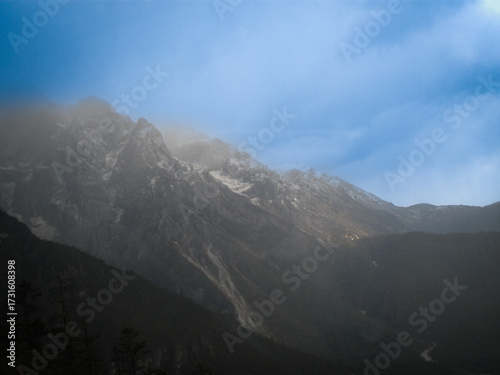 霧に包まれた険しい山と青空の美しい風景