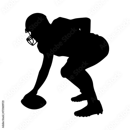 Silhouette of football player in crouched position with ball on field