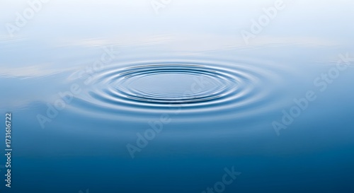 Calm blue water surface with radiating concentric ripples impact drop liquid wave abstract reflection serenity tranquil smooth