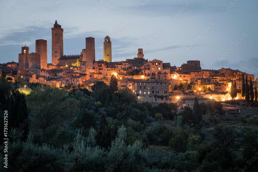 Fototapeta premium Historical city of San Giminiano with all its towers illuminated on a summer evening. Province of Siena, Tuscany, Italy