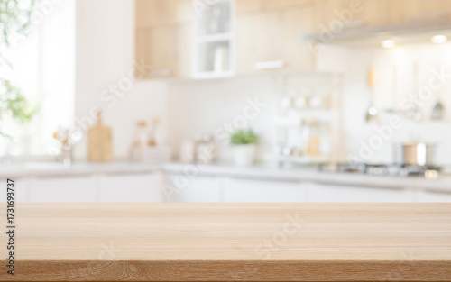 Wooden table top for food product presentation with blurred light kitchen interior background