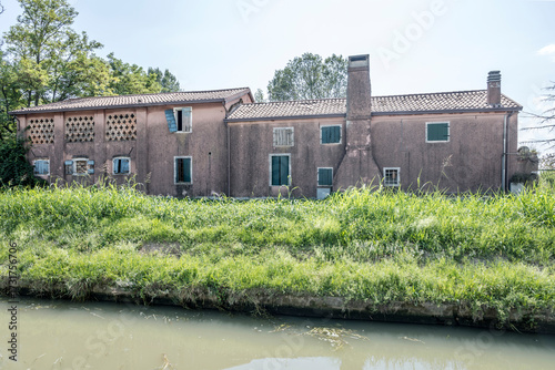 Fotografie crumbling traditional houses with external chimneys on Brenta canal bank, Oriago
