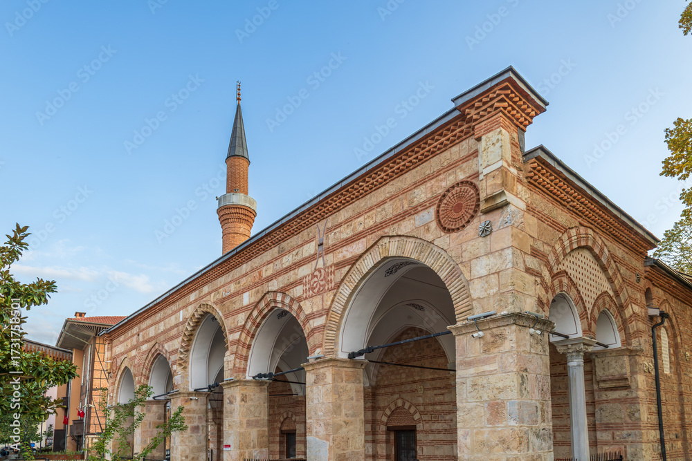 Fototapeta premium Orhan Mosque in Bursa with Ottoman stone and brick architecture, arches, domes and tall minaret.