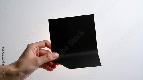 Hand holding illuminated leaf design on a white background