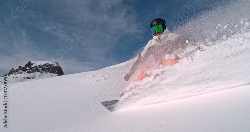 Real professional snowboarder rides at off-piste ski slope. Winter sports concept