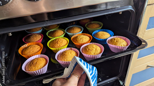 Freshly baked homemade cupcakes in colorful silicone molds inside oven