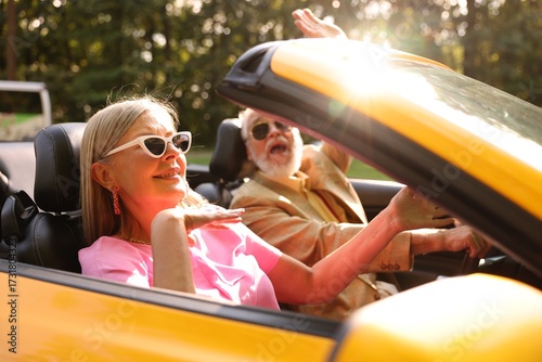 Tableau sur toile Senior couple enjoying cabriolet ride in city, selective focus