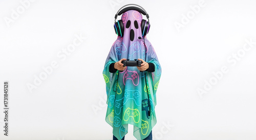 A gamer in a colorful ghost costume plays a video game for Halloween. Child wearing headphones and holding a controller, isolated on a white background.