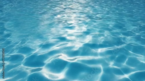 Clear blue pool water with sunlit ripples and sparkling light patterns.