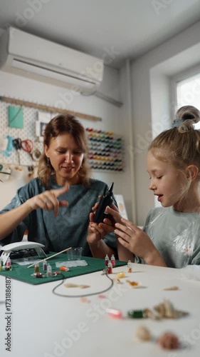 DIY workshop at home with child and parent making resin pendants, creative hobby and family project together.