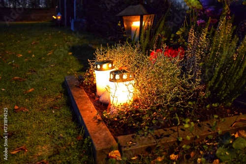 Photos Grave candle lit at a cemetery at all hallows eve.