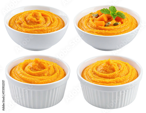 Four small white bowls of orange pumpkin puree, garnished with pumpkin pieces and seeds