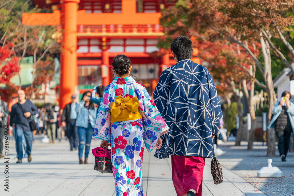 Fototapeta premium Couple wearing traditional japanese kimono clothes walking towards shrine in Kyoto